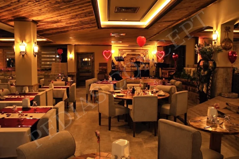 Pedias Concept Olympia Kapalı Alan’da akşam ışıklarıyla hazırlanmış restoran masaları