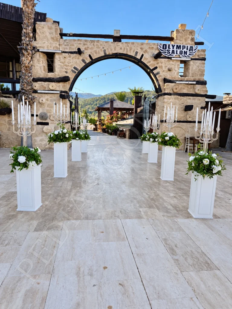 Pedias Concept Olympia Açık Alan’da çiçekli sütunlarla hazırlanan taş kemerli giriş
