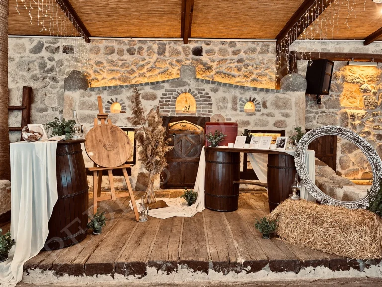 Pedias Concept Hera Kapalı Alan’da taş duvar önündeki ahşap ve varil dekorasyonu