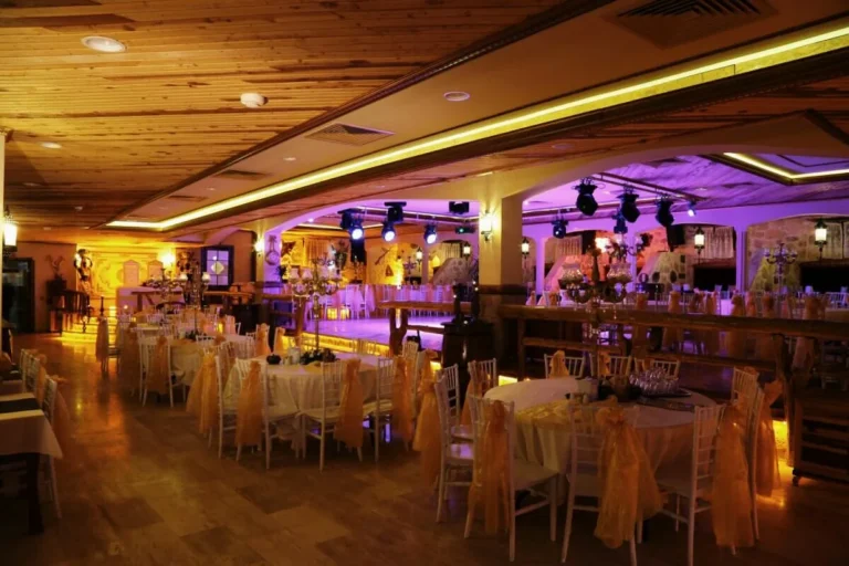 Olympia Kapalı Alan'da ahşap tavan altında hazırlanmış yuvarlak davet masaları